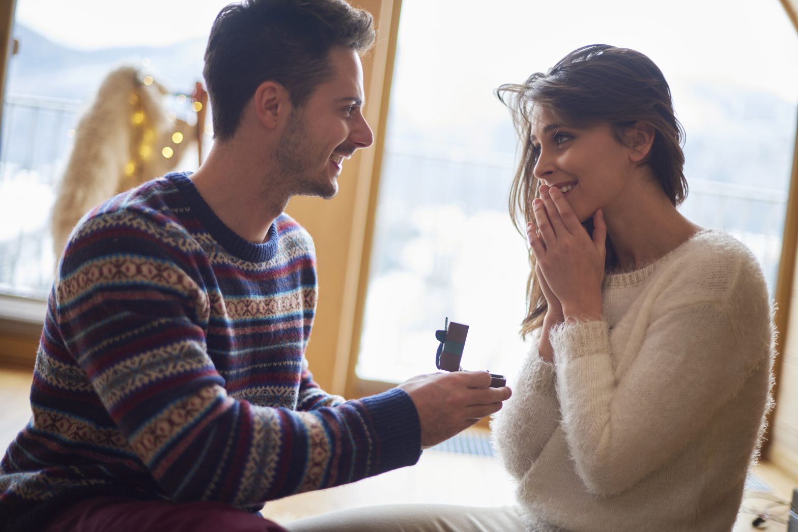 Man proposing to a woman in a cafe.